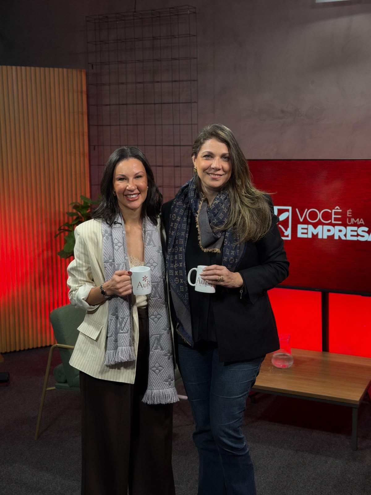 Joice com convidada segurando canecas Auri Club